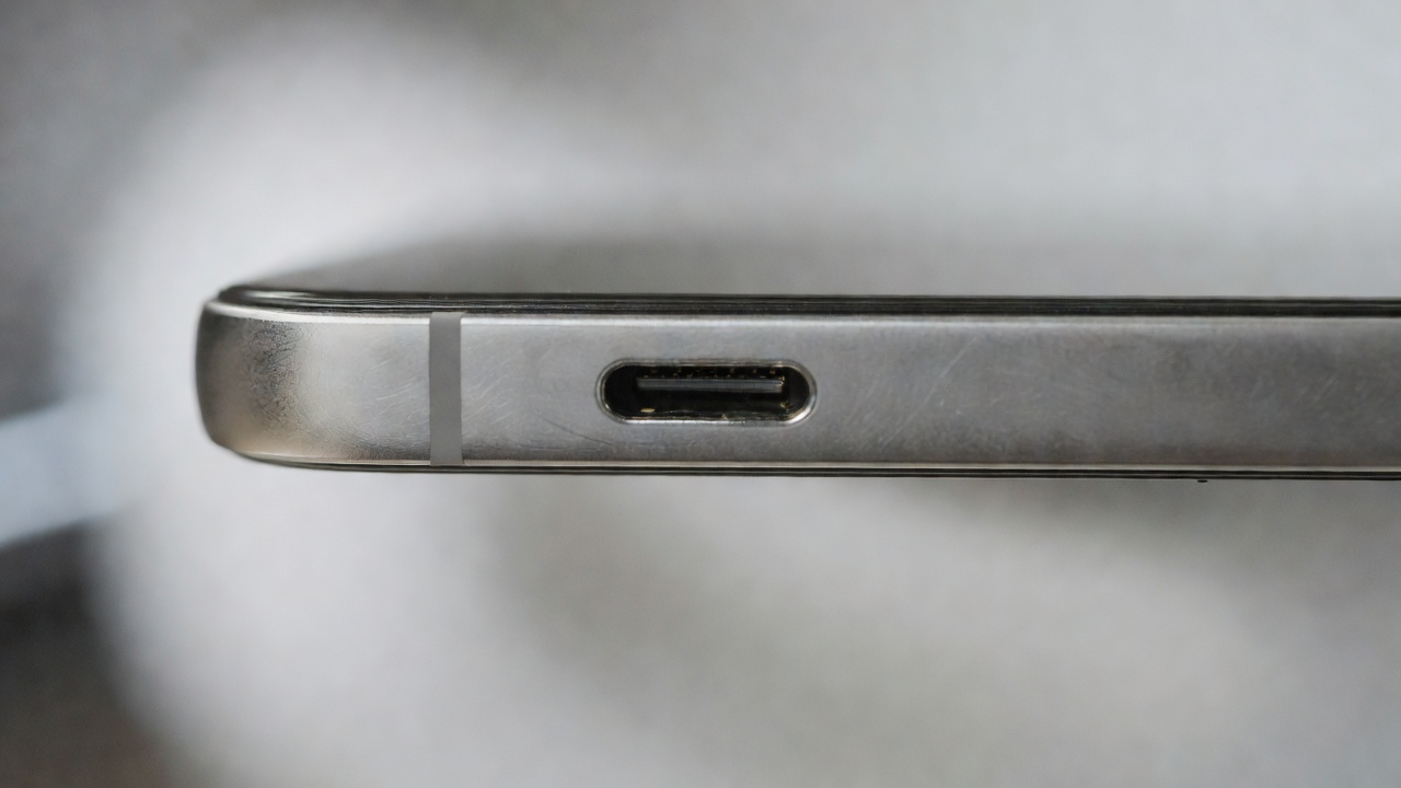Wide macro photo of a USB-C charging port and metal phone edge with shallow focus